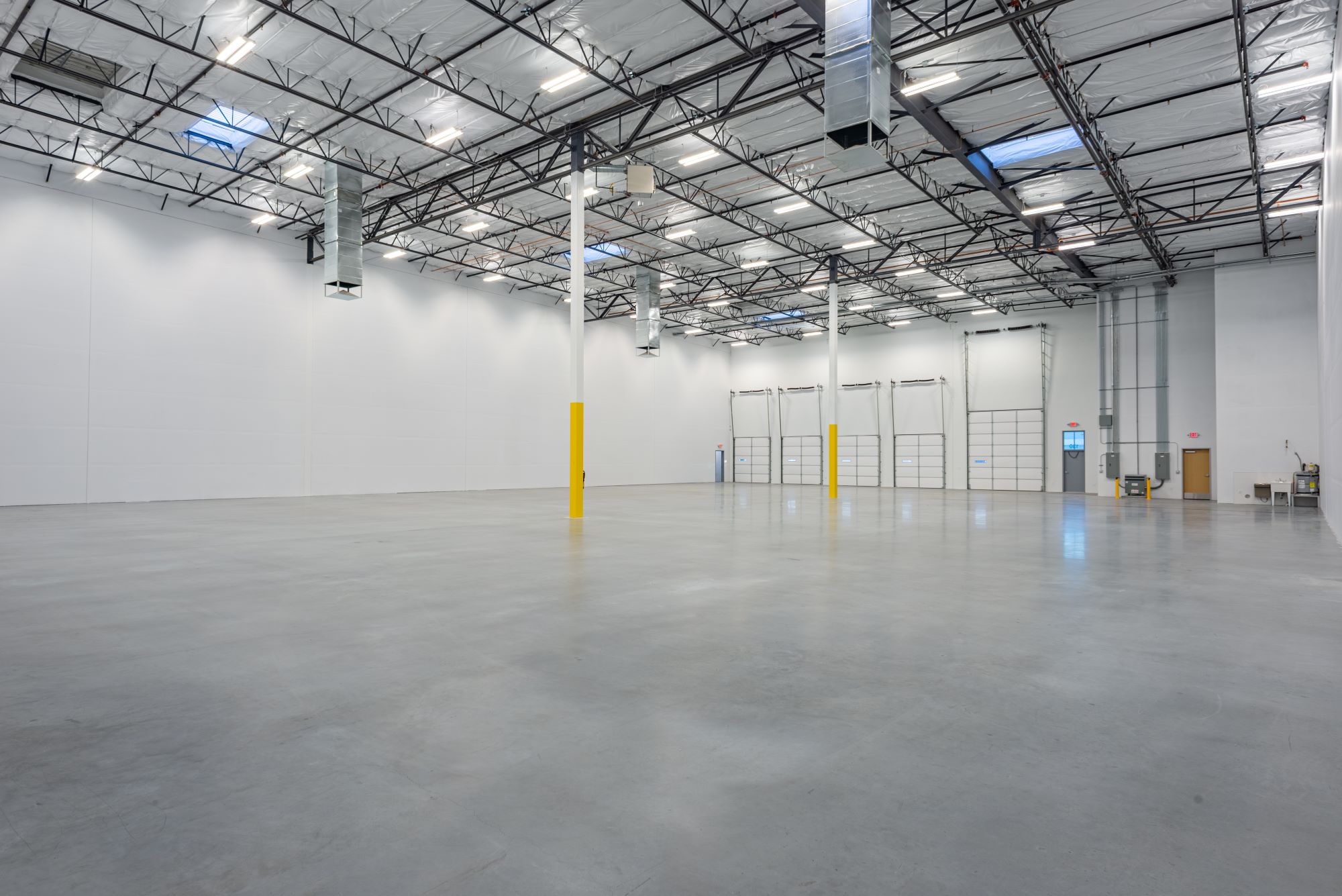 Interior image of an empty warehouse with five dock doors
