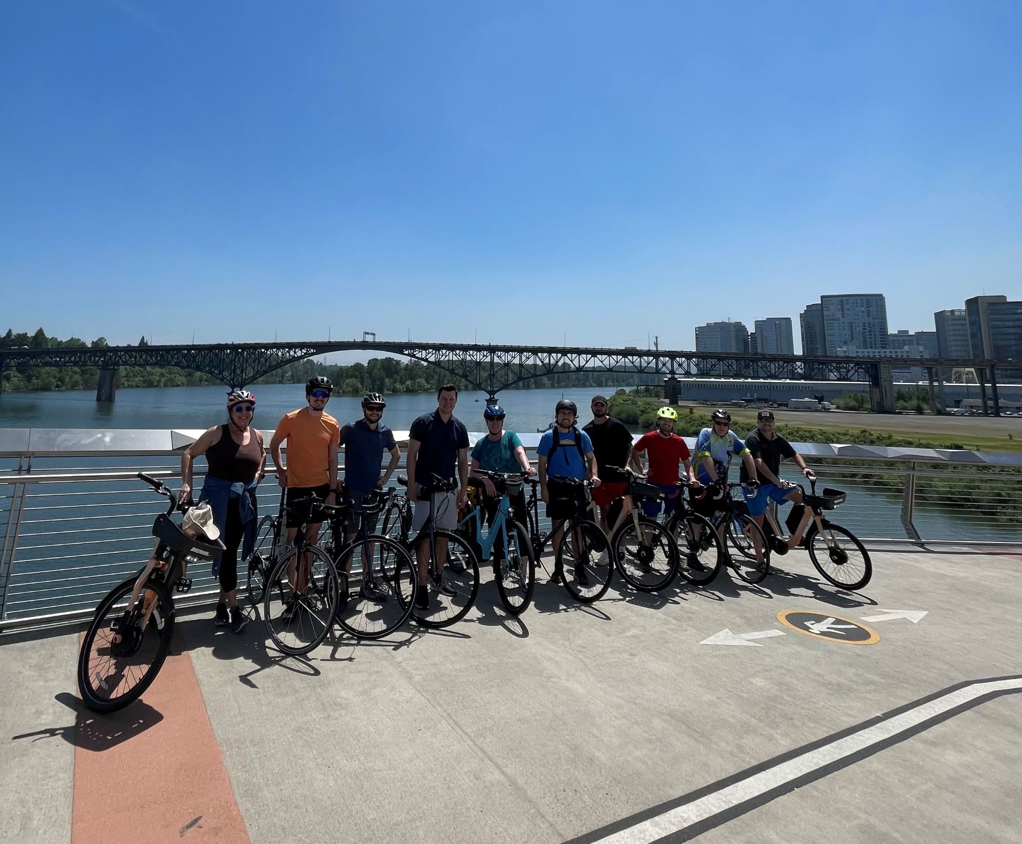 VLMK Staff on a group bike ride posing for a photo on the pedestrian bridge