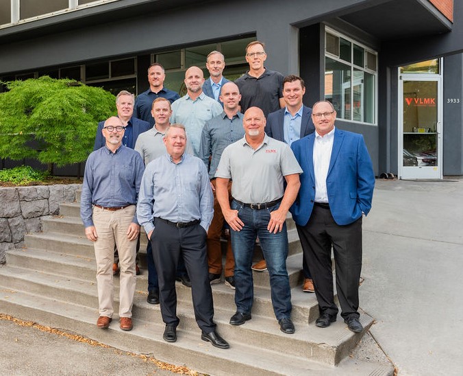 Photo of 12 white males in front of an office space